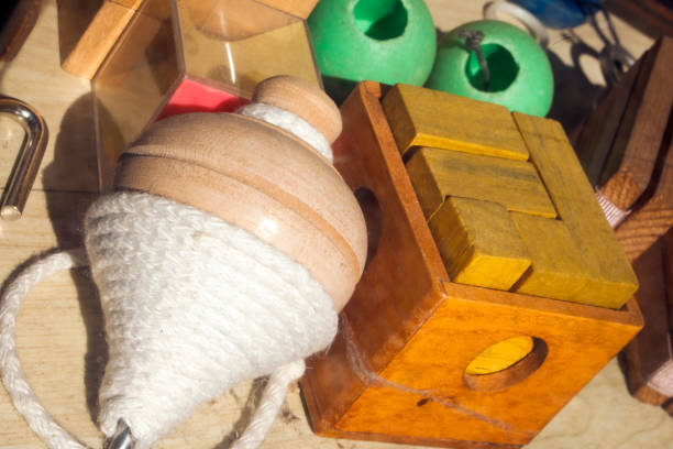 Traditional multicolored games equipment display, puzzle, spinning top, wooden pieces and cord. Galicia, Spain. Close-up view.