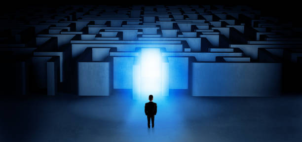 istock Lost businessman standing at illuminated labyrinth entrance 1163497794