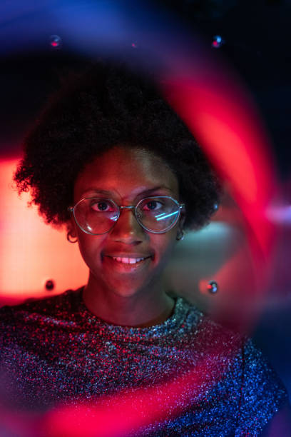 istock Woman at disco club with colorful light effects 1163499511