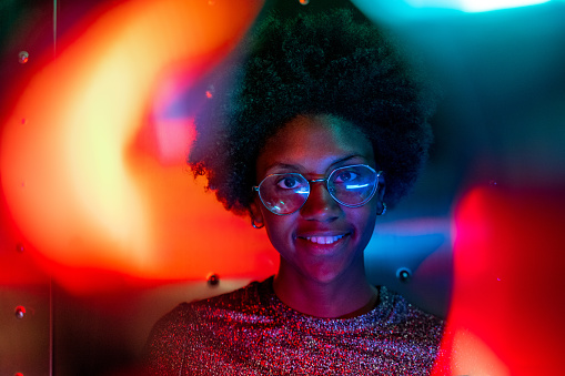 Woman at disco club with colorful light effects