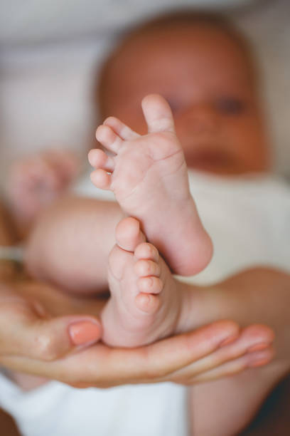 istock Tiny newborn's foot in the mother hands in soft focus 1163500419