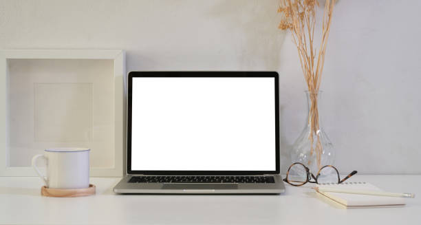 istock Open blank screen laptop on white wooden table 1163500625