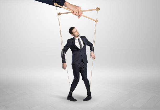 istock Puppet businessman leaded by a huge hand 1163500630