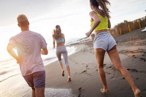 istock Group of sport people jogging on the beach 1163501680