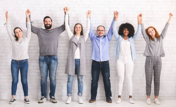 istock Group of successful friendly people raising connected hands 1163502080