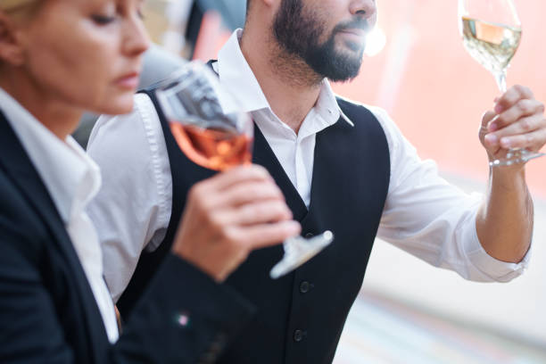 istock Bearded sommelier with glass of white wine checking its quality 1163504037