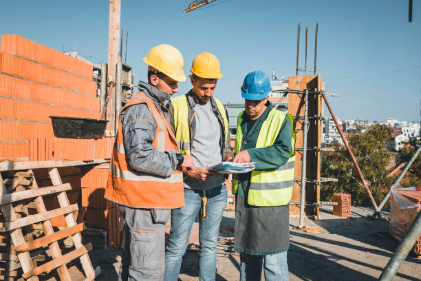 istock Experienced Construction Worker is Explaining Building Project to his Coworkers 1163504152