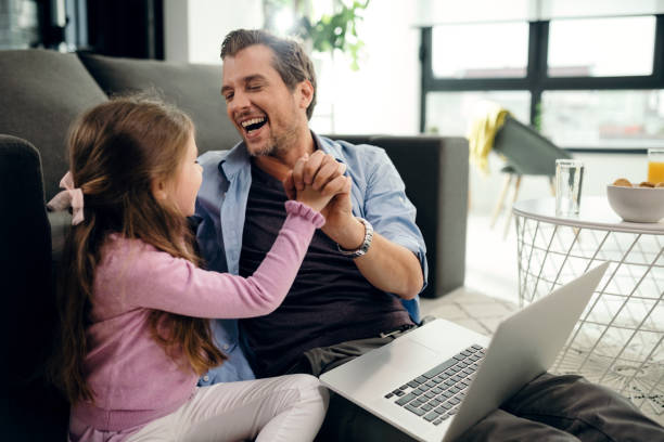 istock Happy father and daughter having fun while holding hands at home. 1163506454