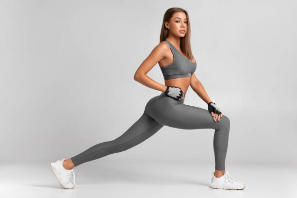 Fitness woman doing lunges exercises for leg muscle workout training. Active girl doing front forward one leg step lunge exercise Fitness woman doing lunges exercises for leg muscle workout training. Active girl doing front forward one leg step lunge exercise pics of girls buttocks stock pictures, royalty-free photos & images