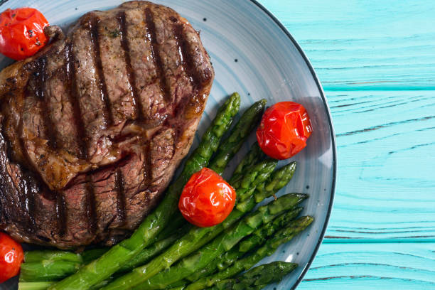 istock Grilled beef steak ribeye with cherry tomatoes and asparagus 1163507630
