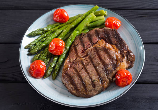 istock Grilled beef steak ribeye with cherry tomatoes and asparagus 1163507631