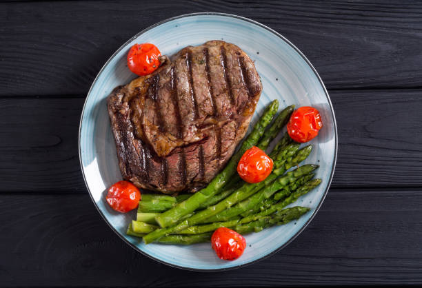istock Grilled beef steak ribeye with cherry tomatoes and asparagus 1163507632