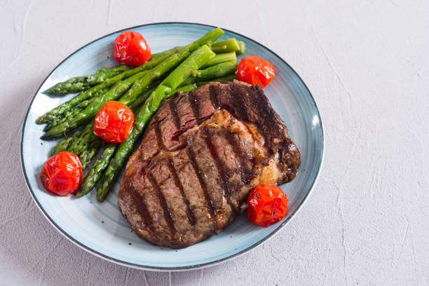 istock Grilled beef steak ribeye with cherry tomatoes and asparagus 1163507636