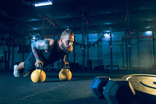 istock Young healthy man athlete doing exercise in the gym 1163508657