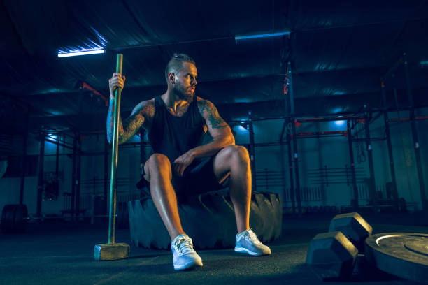 istock Young healthy man athlete doing exercise in the gym 1163508669