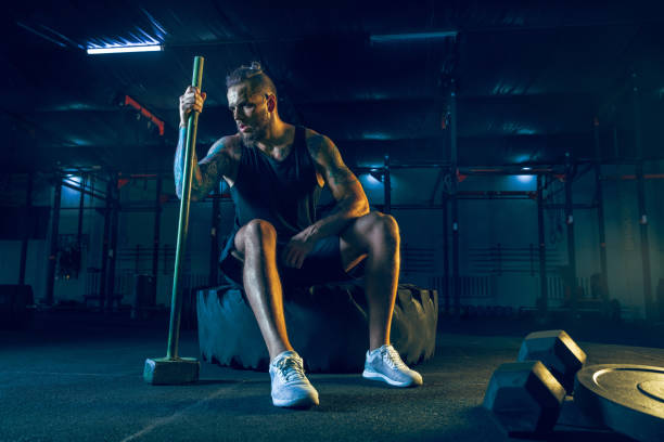 istock Young healthy man athlete doing exercise in the gym 1163508674