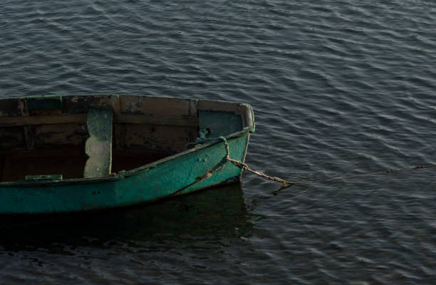 istock Old green boat floating isolated in the sea 1163509277