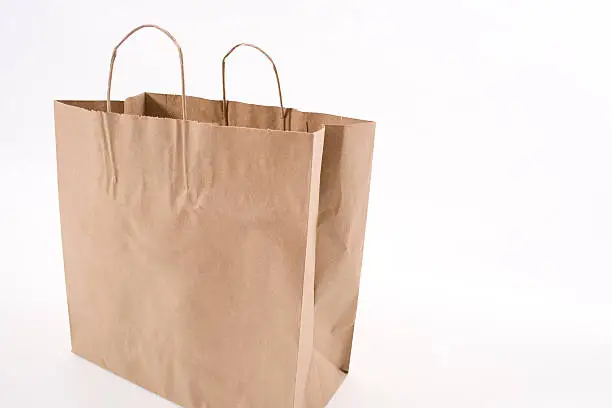 Empty brown paper shopping bag isolated on white.