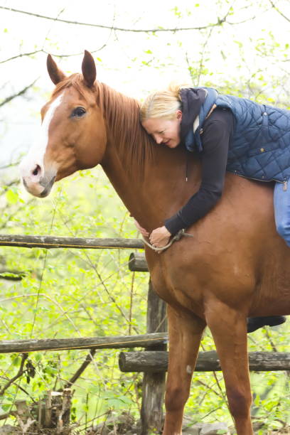 istock Relaxed and Happy Young Woman Hugging her Horse while Sitting on it´s Back 1163515416