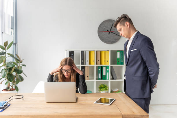 istock Aggressive boss looking menacing at employee woman 1163517434
