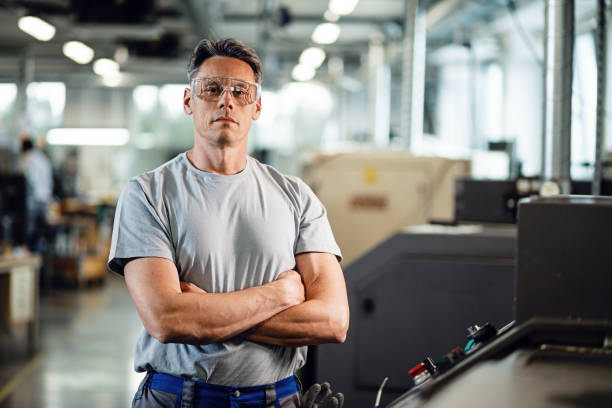 verticale de l'opérateur confiant de machine de cnc dans une usine. - lunettes de protection photos et images de collection