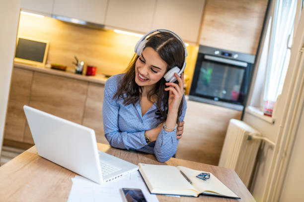 mujer de negocios con auriculares sentados en el escritorio durante el descanso. - digital enhancement audio fotografías e imágenes de stock