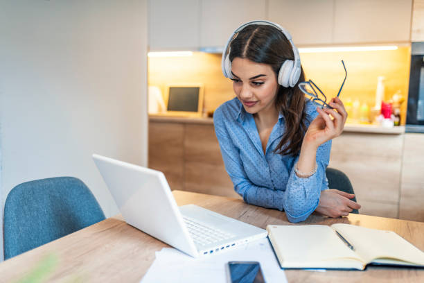 istock Young executive girl watching video lecture on line sitting at home. 1163520562