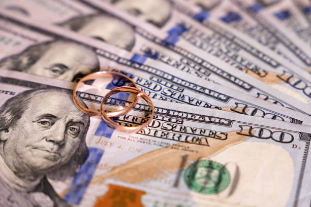 istock Wedding rings on US dollar bills 1163520918