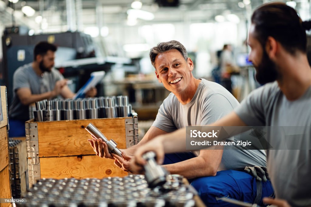 Gelukkige handarbeiders praten terwijl ze samenwerken bij Steel Factory. - Royalty-free Geluk Stockfoto