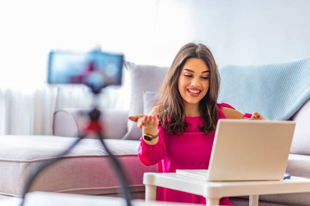 istock Young woman looking at camera while working on laptop 1163521265