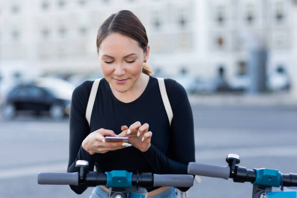 istock A woman using a mobile phone for unlocking an electric scooter by app 1163524251