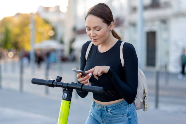 istock A woman using a mobile phone for unlocking an electric scooter by app 1163524265