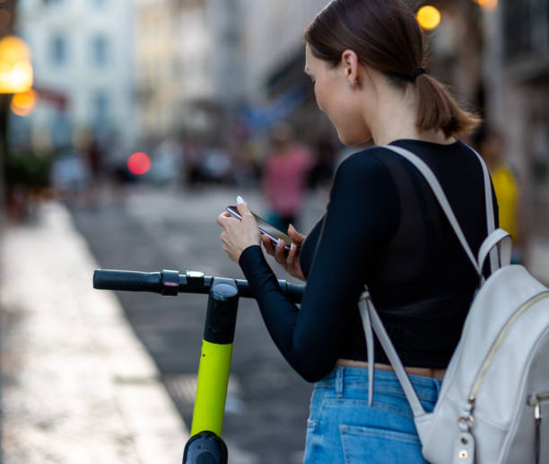 istock A woman using a mobile phone for unlocking an electric scooter by app 1163524276