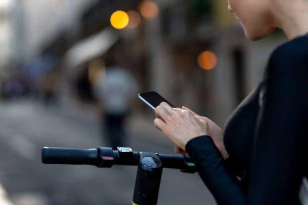 istock A woman using a mobile phone for unlocking an electric scooter by app 1163524357