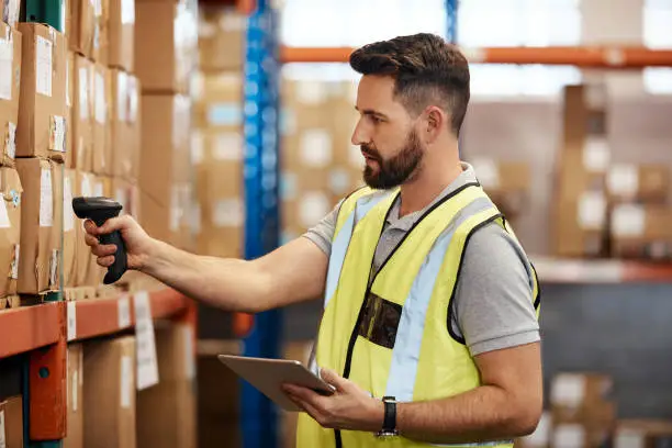 Cropped shot of a handsome young male warehouse worker checking stock
