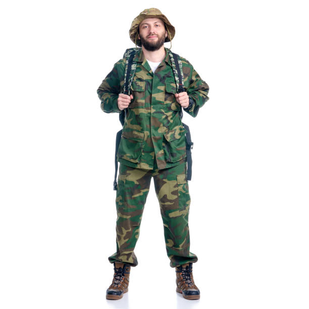 istock Man in camouflage clothes with backpack hiking standing looking 1163524706