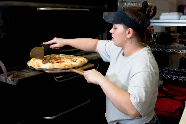 Photo of Proud Business Manager checking on a Pizza.