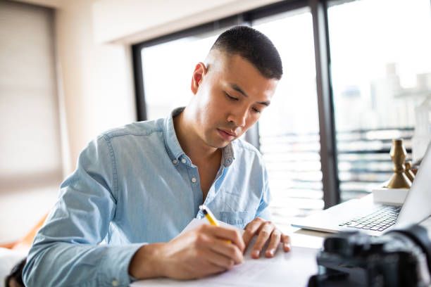 istock Good-looking Chinese man Signing paper documents 1163526679