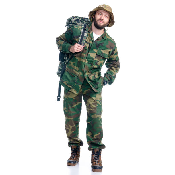 istock Man in camouflage clothes with backpack hiking standing looking 1163526834
