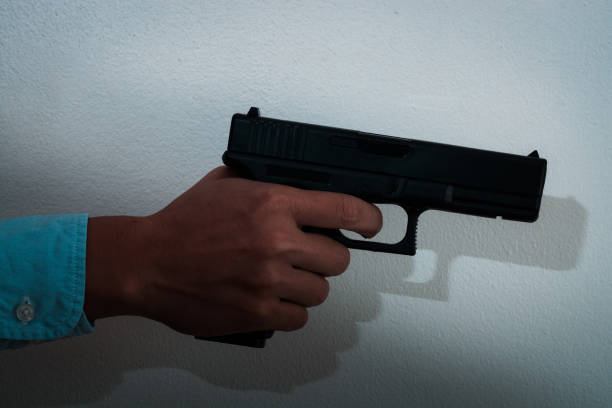 istock Man shooting gun in dark tone, close-up image 1163527103