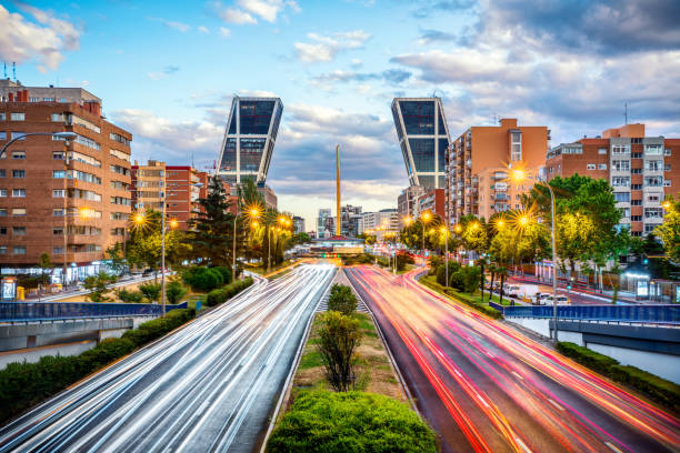 financial district with Kio towers in paseo de la castellana avenue at dusk, Madrid. Spain car trails in paseo de la castellana avenue with kio towers at dusk in Madrid, Spain city street street man made structure place of work stock pictures, royalty-free photos & images