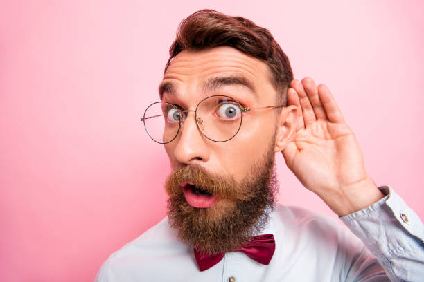 close up portrait of funny funky loony geek astonished hipster holding palm near ear isolated pastel background - spy secrecy top secret mystery imagens e fotografias de stock