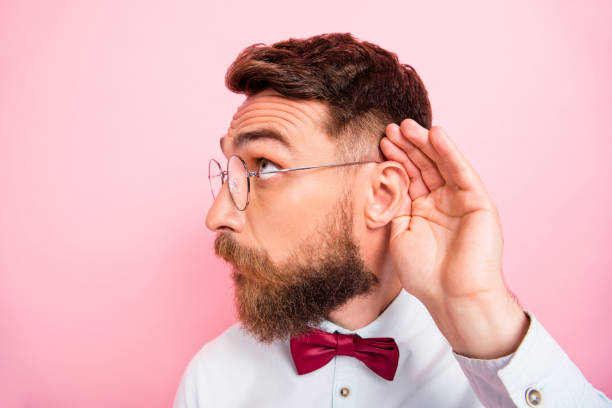 close-up photo of funny funky smart concentrated hipster gentleman holding palm near ear catching familiar sound isolated pastel background - spy secrecy top secret mystery imagens e fotografias de stock