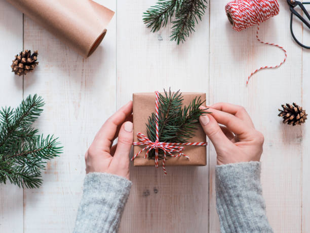 woman packing presents for christmas in boxes - hand wrap imagens e fotografias de stock