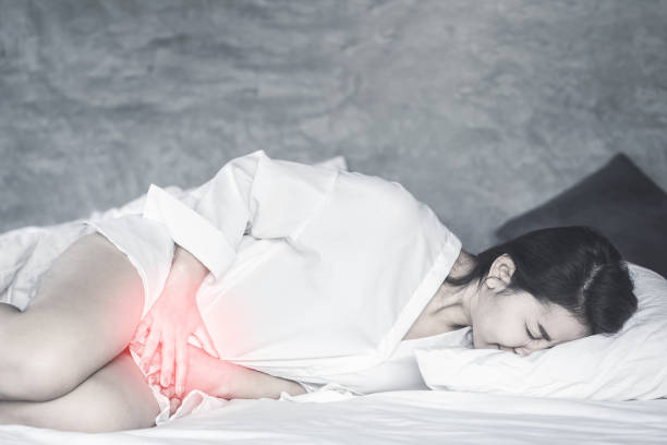 femme asiatique s'étendant sur la main de lit retenant son entrejambe souffrant de douleur, démangeaison - thrush yeast fungus illness photos et images de collection