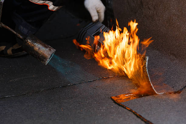 istock Laying waterproofing by heating roofing felt with fire. 1163533566