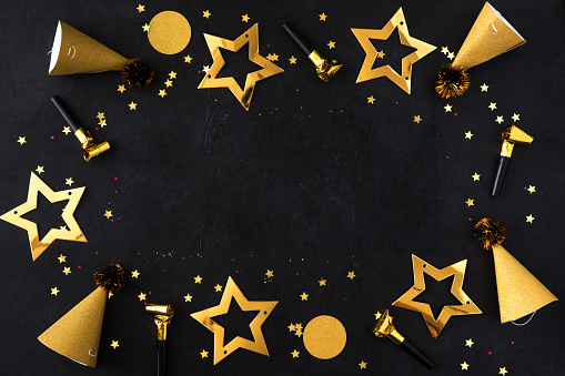 Christmas composition. Gold Christmas frame made of balls, golden decorations on black background. Flat lay, top view, copy space