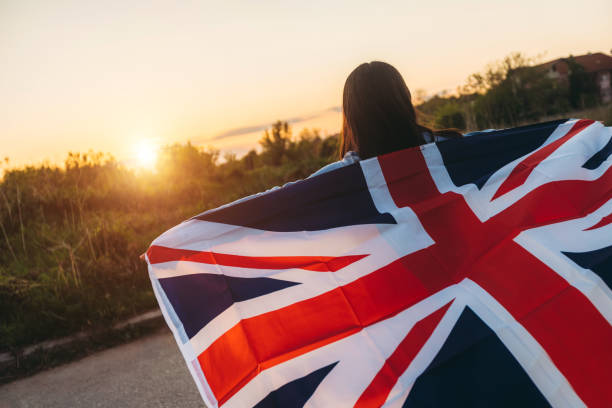 istock Woman spreading british flag outdoor 1163534988