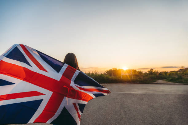 istock Woman spreading british flag outdoor 1163535052