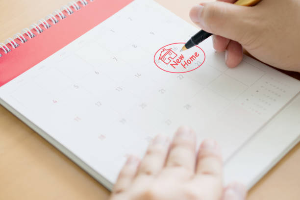 istock Hand writing in calendar plan and coins concept, New home 1163536502